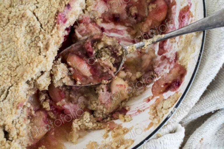 Close up of a freshly baked apple and blueberry crumble dessert.