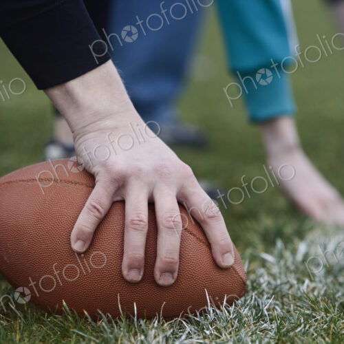 Close up of a hand holding an oval football on the line, during a game of non-contact… Close up of a hand holding an oval football on the line, during a game of non-contact…