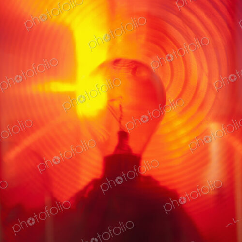 Close up of a lantern and lightbulb, radiating heat and light, red and yellow. Close up of a lantern and lightbulb, radiating heat and light, red and yellow.