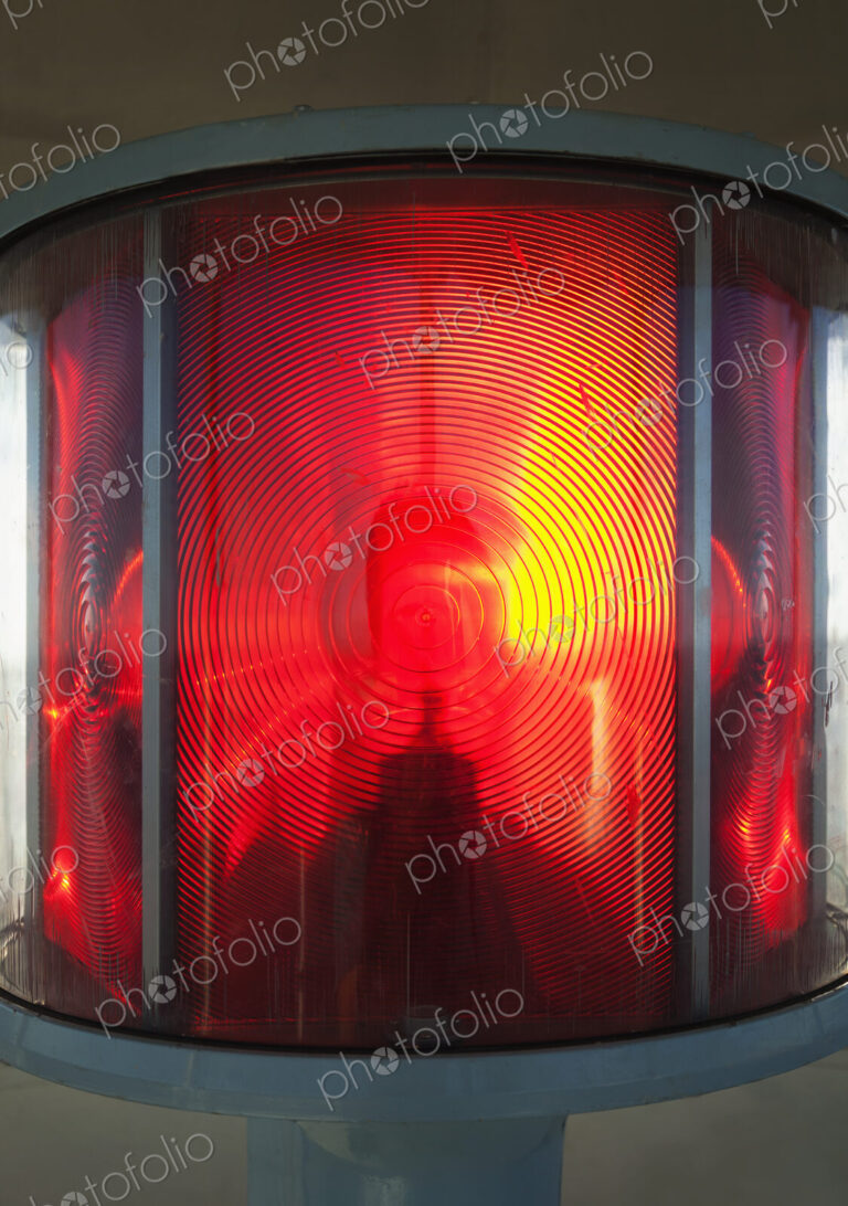 Close up of a lantern and lightbulb, radiating heat and light, red and yellow.