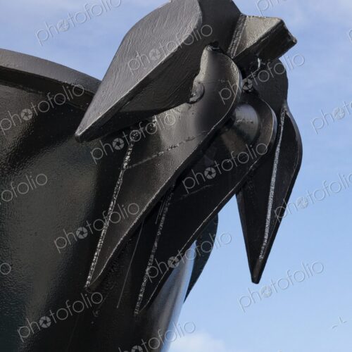 Close-up of a large black anchor mounted on the bow of a ship, the sharp lines and… Close-up of a large black anchor mounted on the bow of a ship, the sharp lines and…