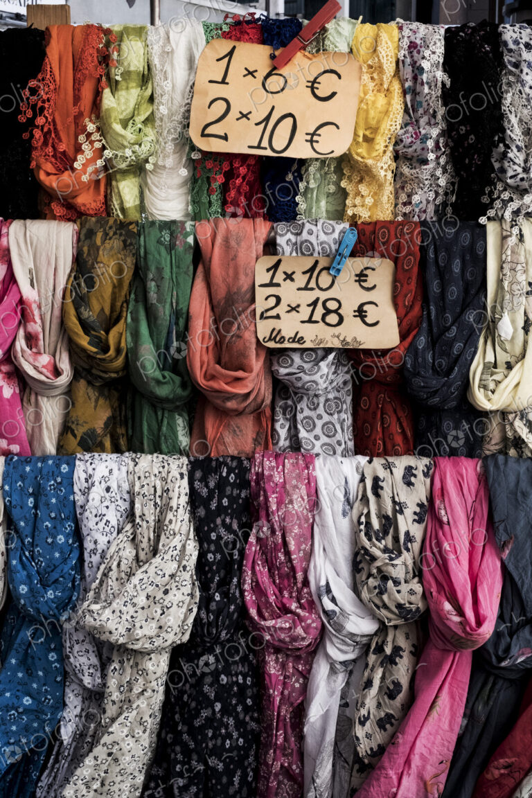 Close up of a large selection of colourful scarves at a market stall.