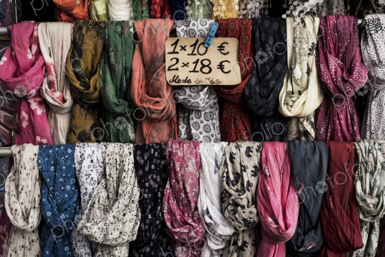 Close up of a large selection of colourful scarves at a market stall.