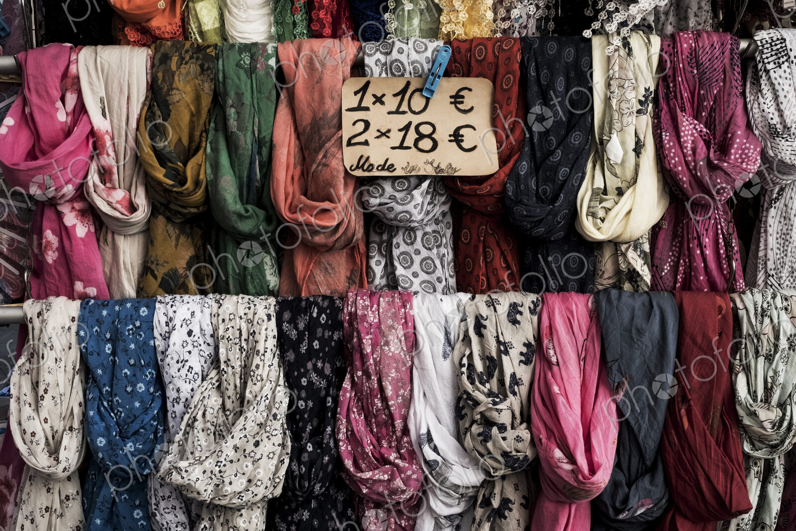 Close up of a large selection of colourful scarves at a market stall.