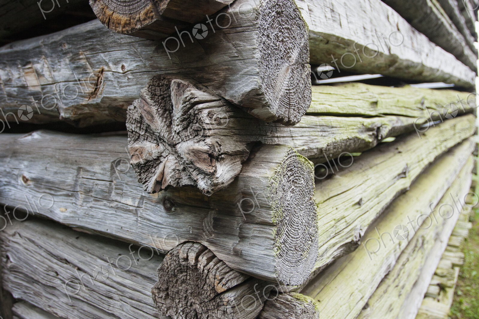 Close up of a log cabin with weathered wooden logs fitted closely together.