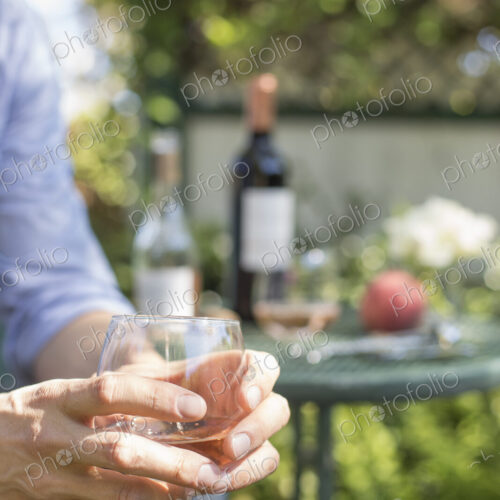 Close up of a man holding a glass of rose wine. Close up of a man holding a glass of rose wine.