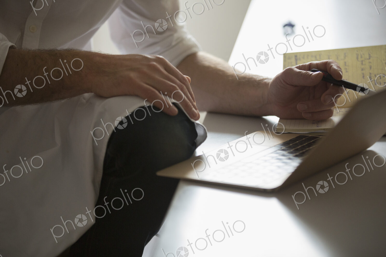 Close up of a man working on a laptop computer.