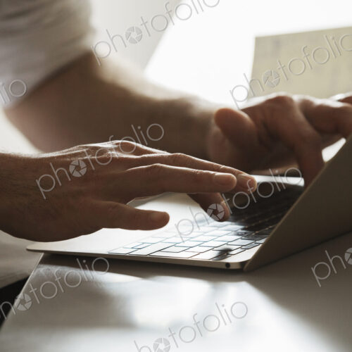 Close up of a man working on a laptop computer, typing. Close up of a man working on a laptop computer, typing.