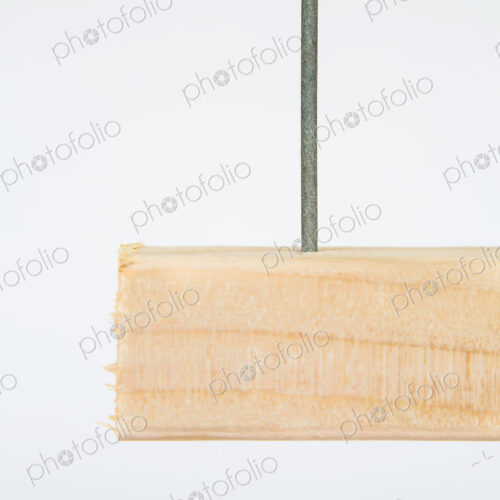 Close up of a metal nail in a block of Spruce wood, a 2x4 wood stud plank. Close up of a metal nail in a block of Spruce wood, a 2x4 wood stud plank.