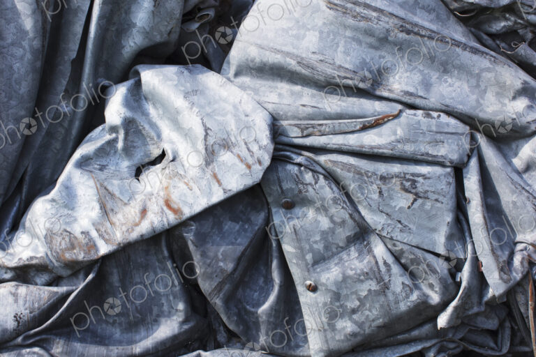 Close up of a pile of dented, crumpled and rusty metal.