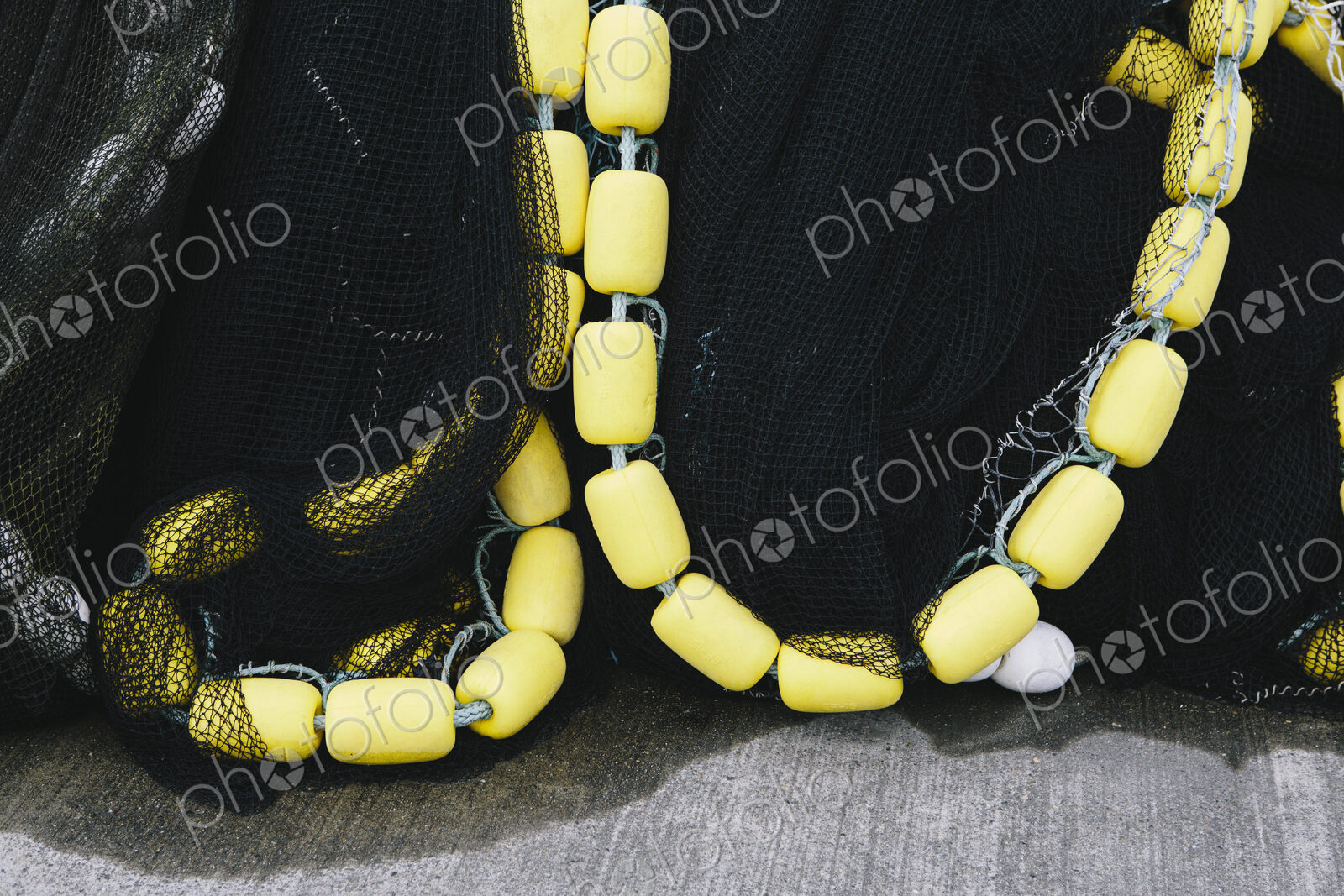 Close up of a pile of tangled up commercial fishing nets with floats attached.