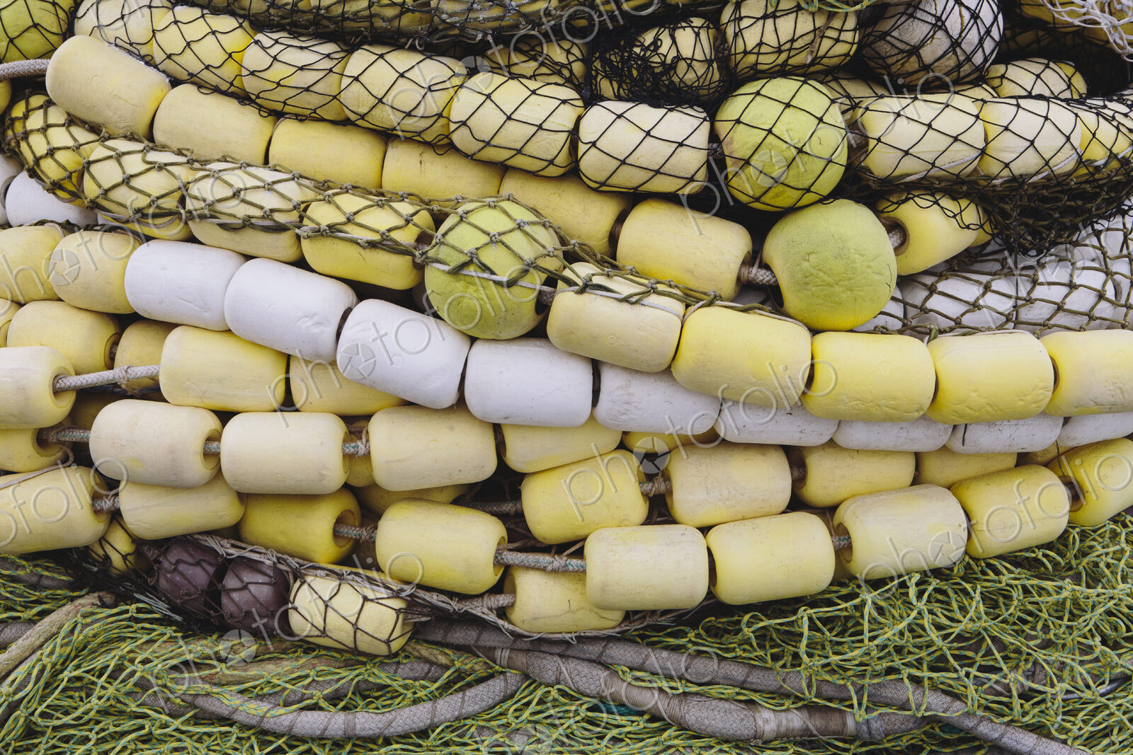 Close up of a pile of tangled up commercial fishing nets with floats attached.