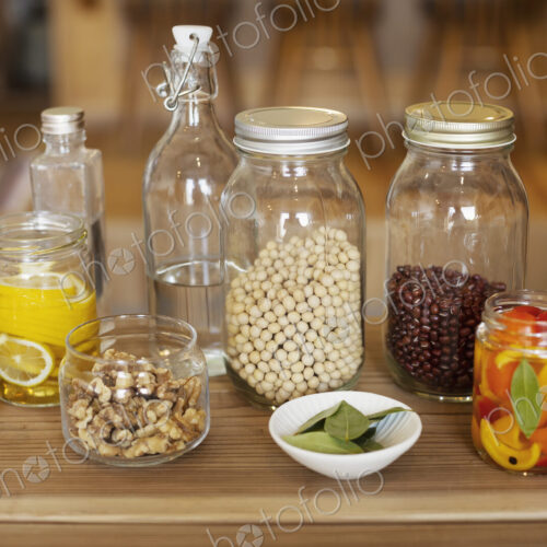 Close up of a selection of condiments and dried pulses in glass jars. Close up of a selection of condiments and dried pulses in glass jars.