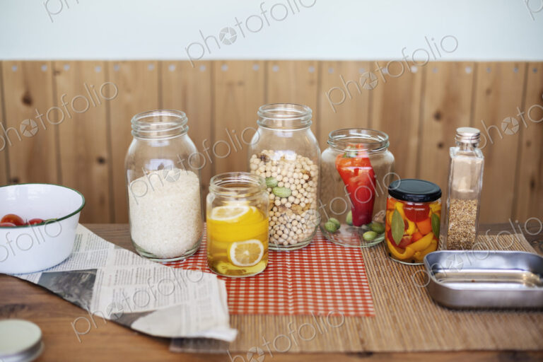 Close up of a selection of foods and condiments in glass jars in a farm shop.