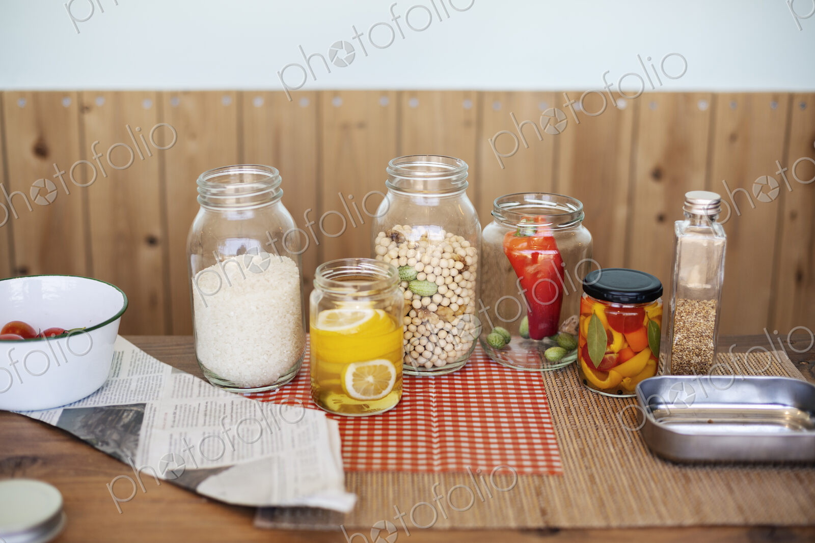 Close up of a selection of foods and condiments in glass jars in a farm shop.