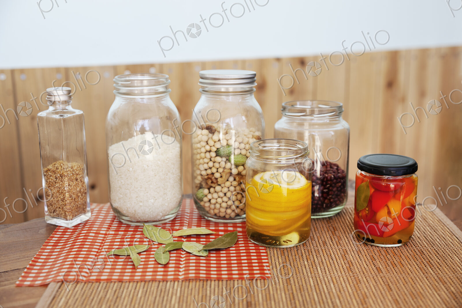 Close up of a selection of foods and condiments in glass jars in a farm shop.