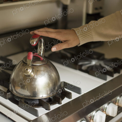 Close up of a stainless steel kettle on a stove.