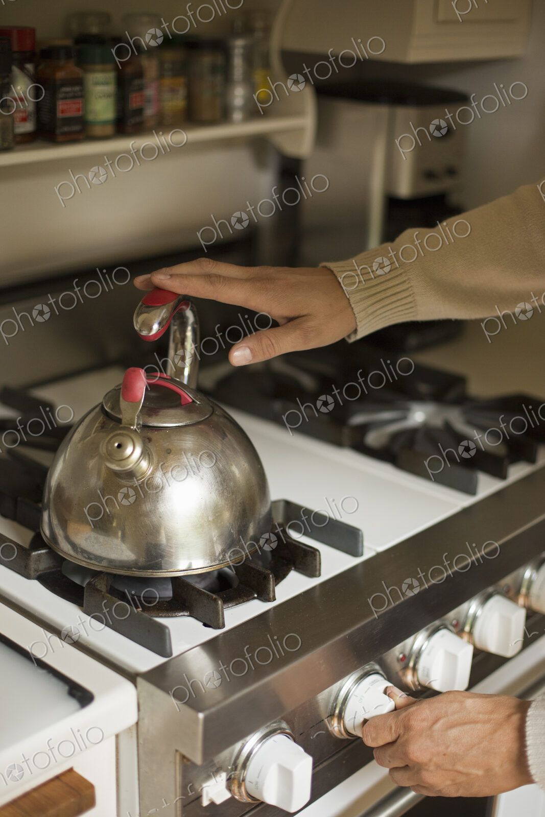 Close up of a stainless steel kettle on a stove.