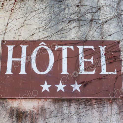 Close up of a three-star hotel sign on grey wall. Close up of a three-star hotel sign on grey wall.