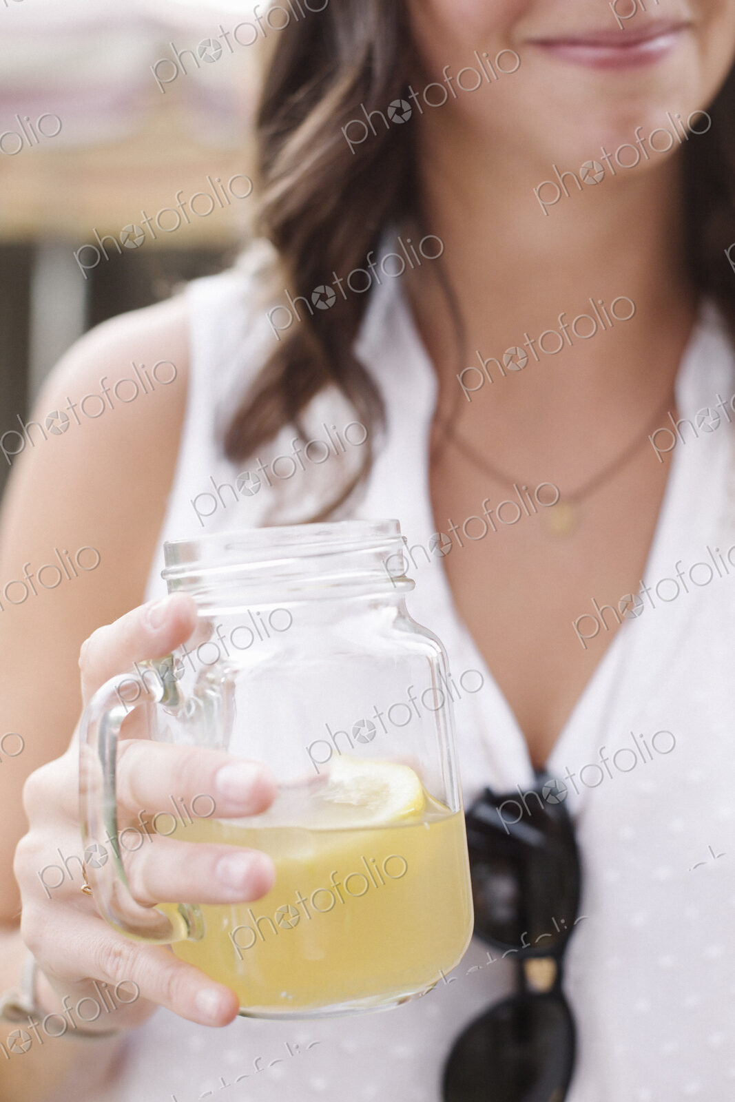 Close up of a woman holding a drink.