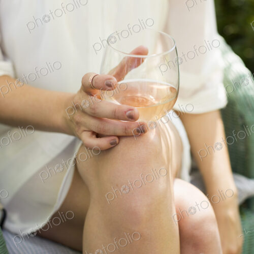 Close up of a woman holding a glass of rose wine. Close up of a woman holding a glass of rose wine.