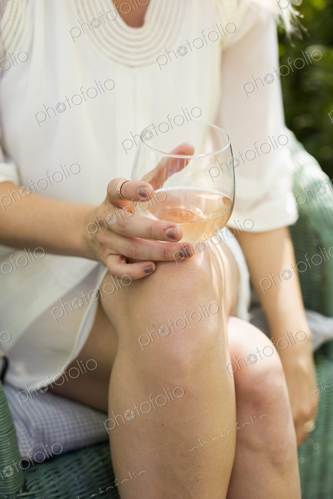 Close up of a woman holding a glass of rose wine.
