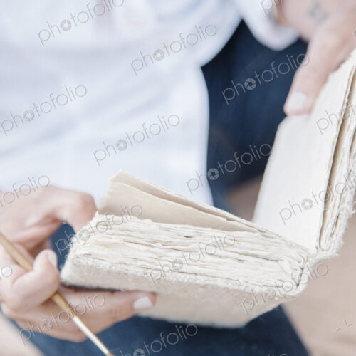 Close up of a woman holding a sketch book and paint brush. Close up of a woman holding a sketch book and paint brush.