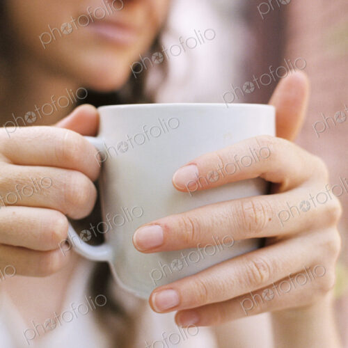 Close up of a woman holding a teacup.