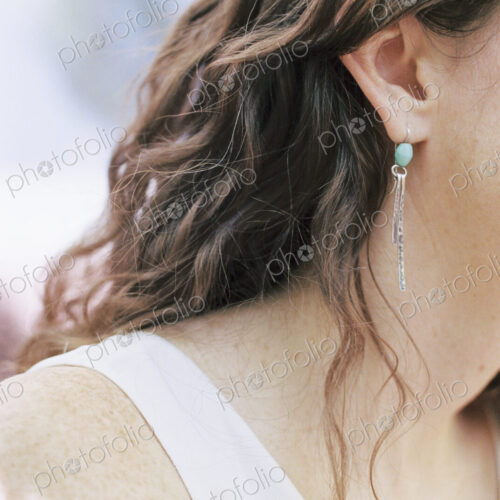 Close up of a woman wearing a silver and turquoise earring. Close up of a woman wearing a silver and turquoise earring.