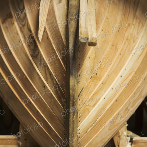 Close up of a wooden boat hull in a boat-builder's workshop.