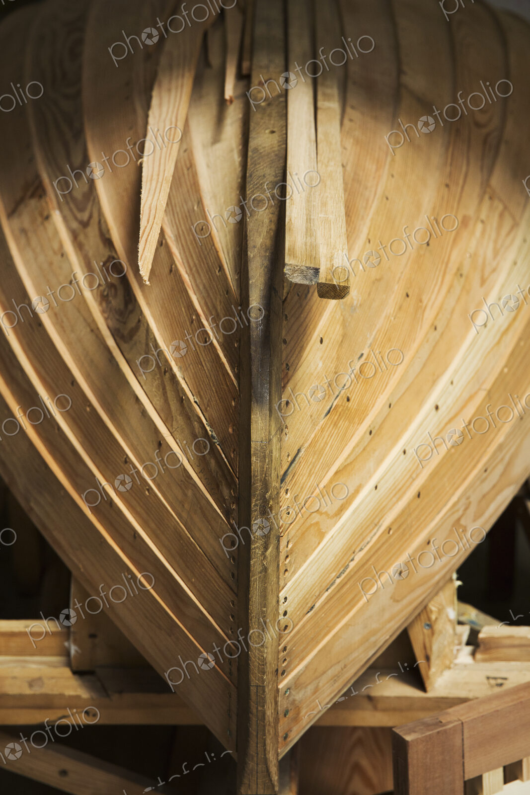 Close up of a wooden boat hull in a boat-builder’s workshop.
