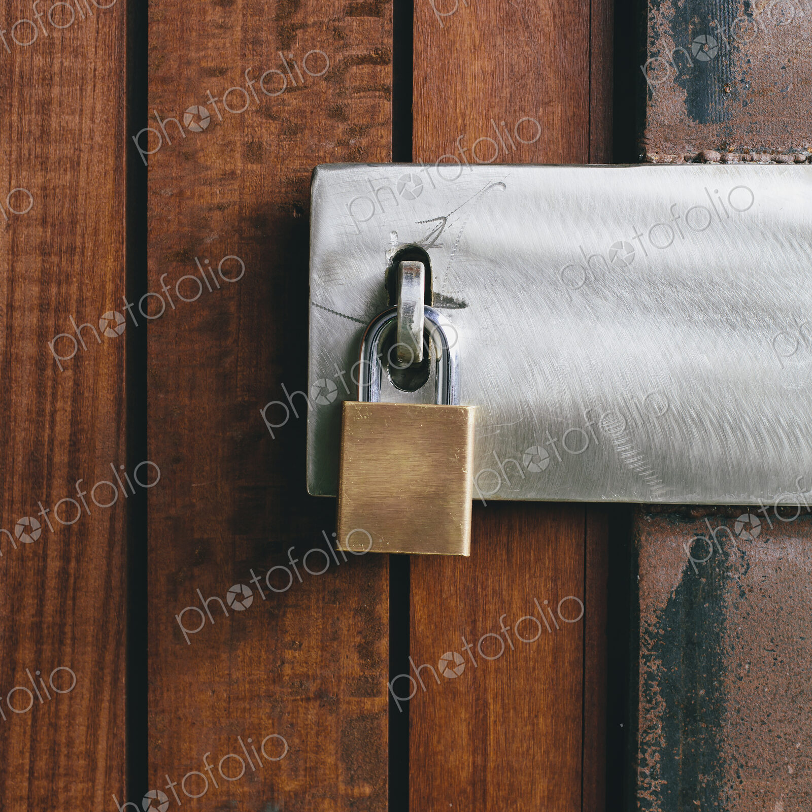 Close up of a wooden doorway, with a padlock.