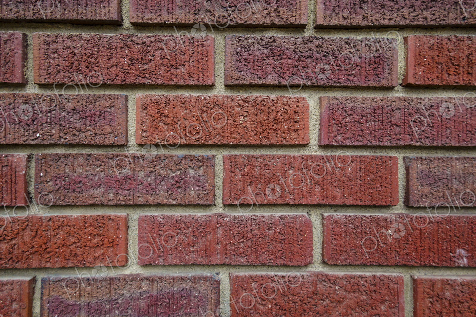Close-up of an old clay red brick wall, laid in a running bond pattern with mortar.