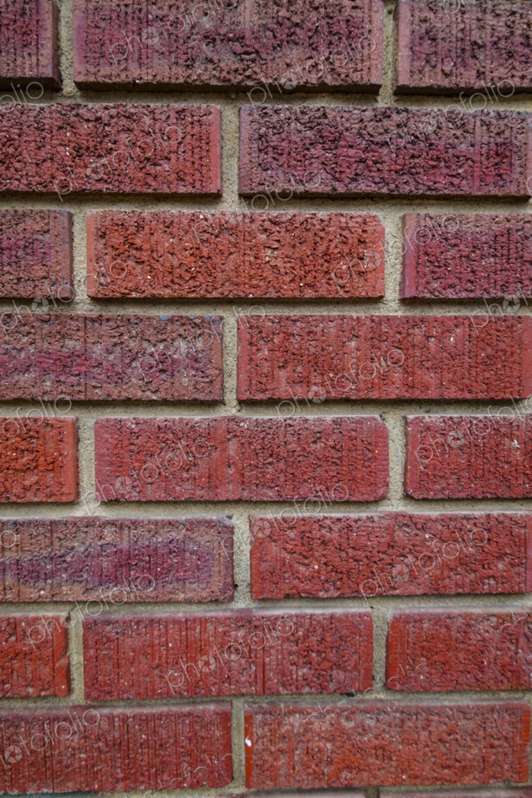 Close-up of an old clay red brick wall, laid in a running bond pattern with mortar.