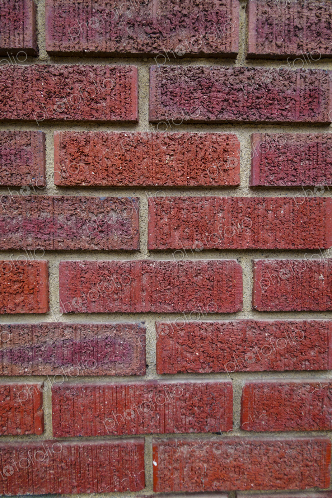 Close-up of an old clay red brick wall, laid in a running bond pattern with mortar.
