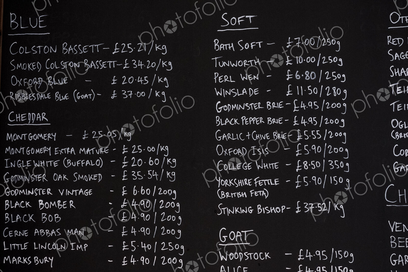 Close up of blackboard with handwritten list of cheese products in a delicatessen.