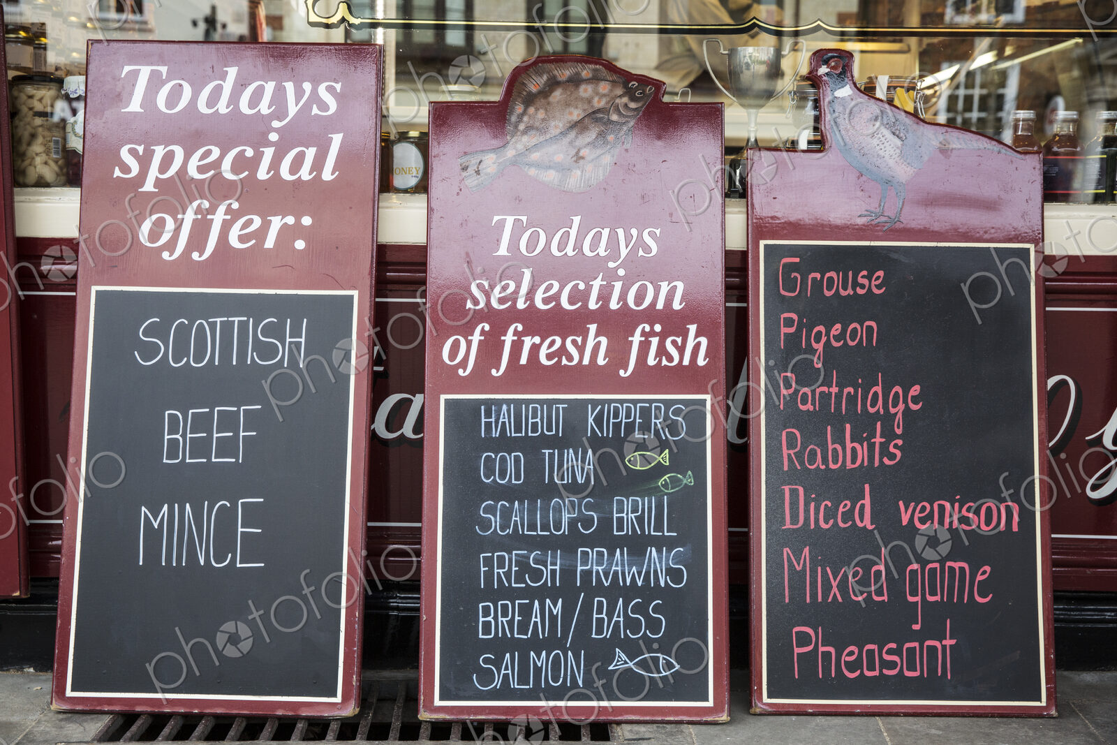 Close up of blackboards on the pavement outside a butcher shop, advertising beef,…
