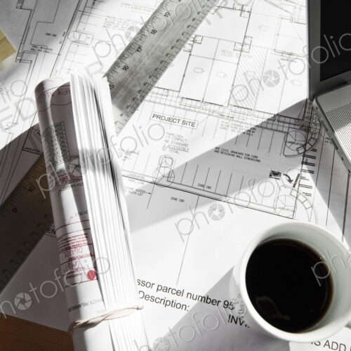 Close-up of blueprints on a desk top in a creative office. Close-up of blueprints on a desk top in a creative office.