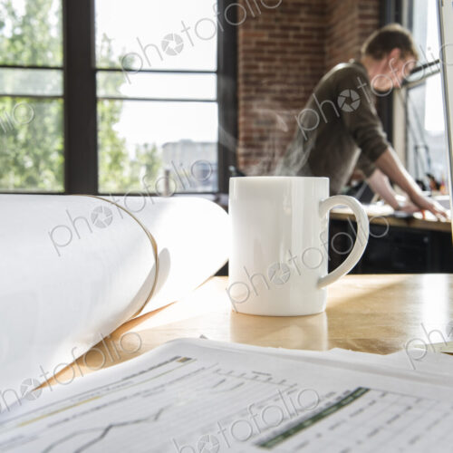 Close-up of blueprints on a desk top in a creative office. Close-up of blueprints on a desk top in a creative office.