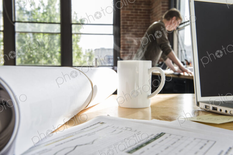 Close-up of blueprints on a desk top in a creative office.
