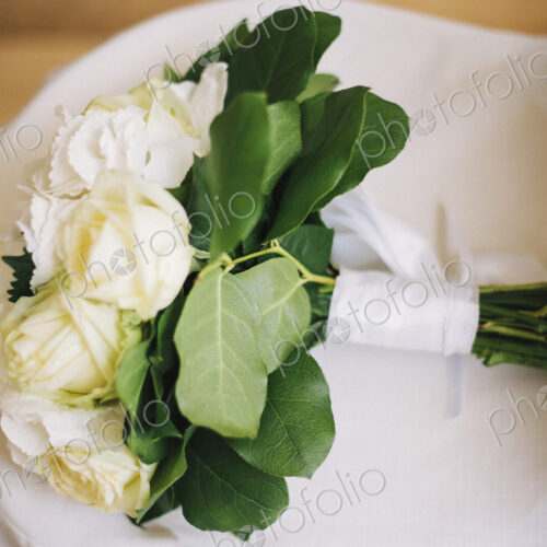 Close up of bouquet of flowers on wedding dress Close up of bouquet of flowers on wedding dress