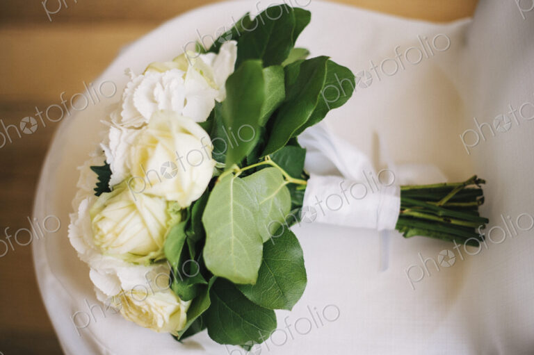 Close up of bouquet of flowers on wedding dress