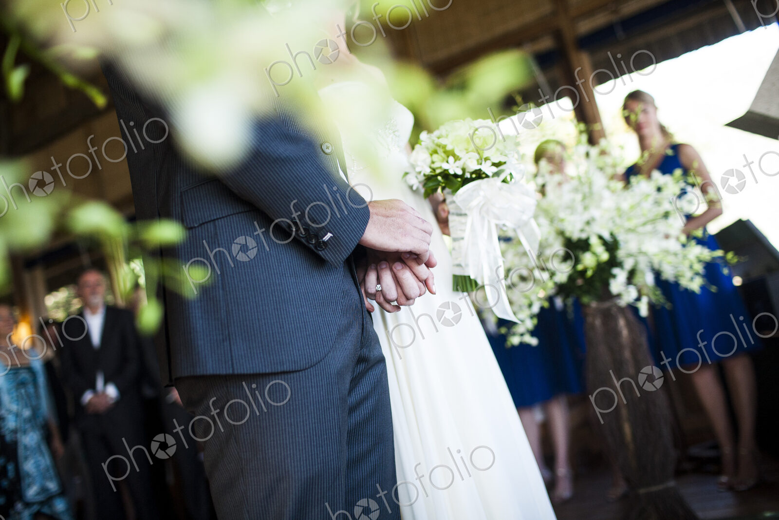 Close up of bride and groom holding hands at a wedding ceremony.