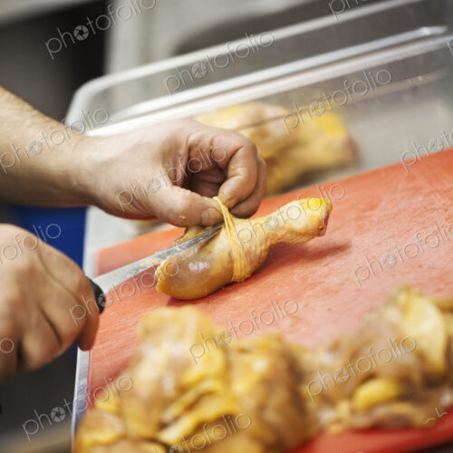 Close up of chef preparing a chicken drumstick in the kitchen at a hotel. Close up of chef preparing a chicken drumstick in the kitchen at a hotel.