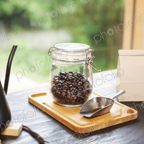 Close up of coffee pot, glass jar with coffee beans and metal coffee shovel on wooden… Close up of coffee pot, glass jar with coffee beans and metal coffee shovel on wooden…