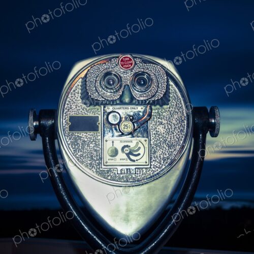 Close-up of coin-operated binoculars at dusk, overlooking Winchester Bay, Oregon. Close-up of coin-operated binoculars at dusk, overlooking Winchester Bay, Oregon.