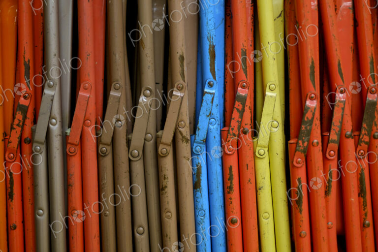 Close-up of colourful stacked chairs.