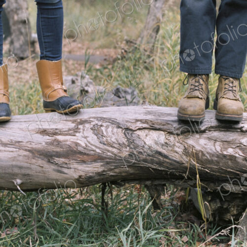 Close up of couple standing side by side on a tree trunk. Close up of couple standing side by side on a tree trunk.