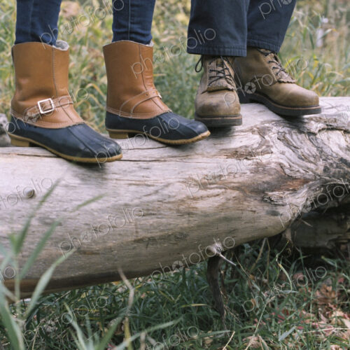 Close up of couple standing side by side on a tree trunk. Close up of couple standing side by side on a tree trunk.
