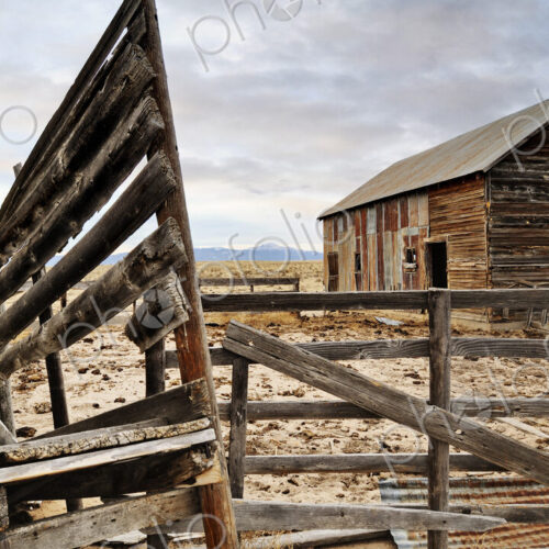 Close up of dilapidated fence and barn on abandoned farm Close up of dilapidated fence and barn on abandoned farm